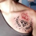 Tatuaje en el hombro,
corona roja con diamante y hojas de laurel