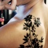 Black flowers tattoo on shoulder blade