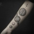 Tatuaje en el antebrazo,
planetas diferentes de color gris