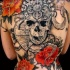 grigio nero cranio con fiori tatuaggio pieno di schiena