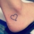 contorno cuore nero piccolo tatuaggio su caviglia