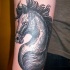 Schwarzes Pferd Tattoo am Arm