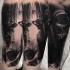 Black ink arm tattoo of human skull with woman figure