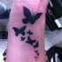Tatuaje  de bandada de mariposas negras en la muñeca