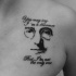 Black ink chest tattoo of Lennon with lettering
