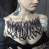 Schwarzes Brust Tattoo mit mystischem Ambigramm