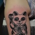 Black ink detailed tattoo of little maneki neko japanese lucky cat with ancient tablet