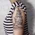 Black ink engraving style shoulder tattoo of simple sailing ship with waves