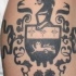 Tatuaje en el brazo, escudo de la familia, tinta negra