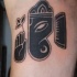 Tatuaje en el brazo, signo de ganesha, tinta negra