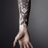 Tatuaje en el antebrazo, formas geométricas volumétricas con hojas