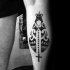 Black ink leg tattoo of interesting ornaments wand cross
