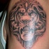Tatuaje en el brazo, cabeza de león, color gris