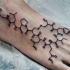 Black ink simple looking chemistry formula tattoo on foot