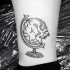 Black ink typical looking leg tattoo of skull shaped globe