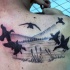 Black ink unusual looking flying ducks tattoo on shoulder