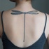 Black minimalist dragonfly tattoo on back for girls