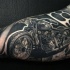 moto nero con tirapugni tatuaggio sul braccio