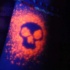 teschio arancione luce nera tatuaggio