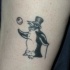 Tatuaje en la pierna,
pingüino de circo en sombrero de copa y con bola