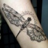 Schwarzes stilisiertes Libelle-Tattoo