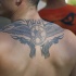 Black tribal wings tattoo on upper back