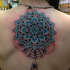 Blue colored illustrative style back tattoo of cool flower with small spider