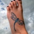 Blue dragonfly tattoo on leg