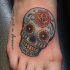 Tatuaje en la pierna, calavera de azúcar azul pequeña