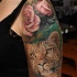 Tatuaje en el brazo,
leopardo muy realista con flores delicadas