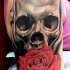 Breathtaking realism style colored large shoulder tattoo of small butterfly with skull and rose flower