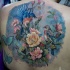 Tatuaje en la espalda,
dibujo en colores pastel de pájaros con flores y mariposas