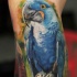 Atemberaubender sehr detaillierter und farbiger lustiger Papagei Tattoo am Bein