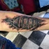 Tatuaje en el antebrazo, cerradura de combinación 3D debajo de la piel rasgada
