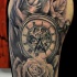 Tatuaje en el hombro,
reloj mecánico entre rosas