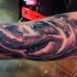 Carelessly painted big shark tattoo on leg