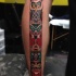 Tatuaje en la pierna, tótem antiguo multicolor
