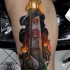 Tatuaje en la pierna,
faro con piedras y antorchas