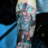 Cartoon style colored arm tattoo of Deadpool with crossed swords