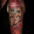 Cartoon style colored shoulder tattoo of creepy doll with clock and flowers