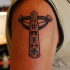 Cartoon style colored shoulder tattoo of ancient statue with symbols
