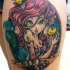 Cartoon style colored thigh tattoo of seductive mermaid with lettering and fishes