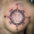 Celtic style black and white symbol tattoo on chest with lettering
