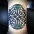 Celtic style colored wrist tattoo of interesting symbol