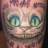 Tatuaje en el brazo, sonrisa del gato de cheshire, inscripción largo