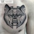 Tatuagem de peito desenhada por Valentin Hirsch de cabeça de lobo rachado com crânio humano