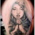 Tatuaje en el brazo,
mujer triste en capucha que ora