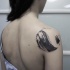 Circle shaped black ink shoulder tattoo of big wave