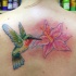 Tatuaggio colorato sulla schiena il colibrì &il fiore rosa