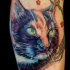 Tatuaggio colorato sulla gamba il ritratti del gatto nero